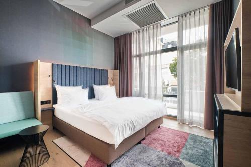 a bedroom with a large bed and a television at The Flamingo in Timmendorfer Strand