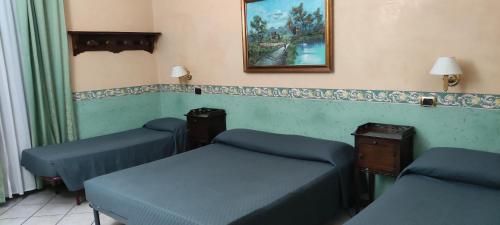 Habitación con 3 camas y una foto en la pared. en Hotel Montreal Uno en Roma