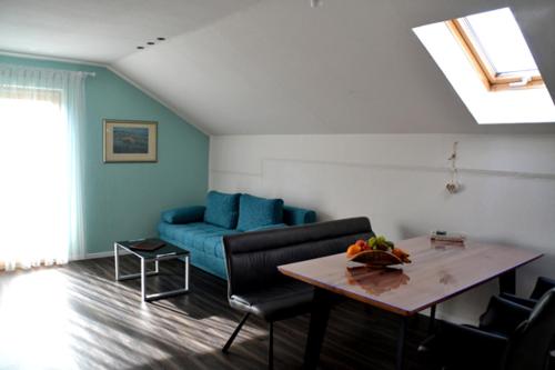 a living room with a blue couch and a table at Pension Anna in Bodenmais