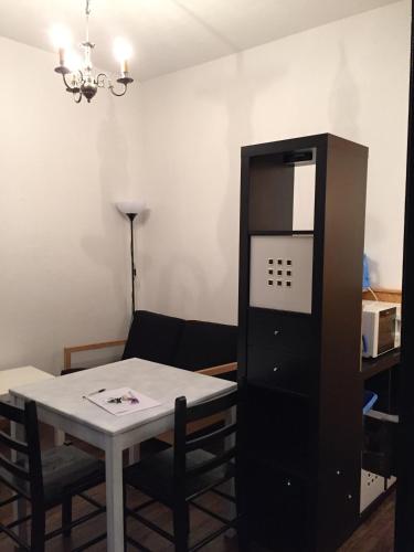 a dining room with a table and a black cabinet at Nancy Malzeville F1 + Terrasse 2 minutes de la vieille ville de Nancy in Malzéville