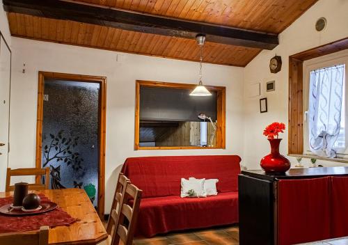 uma sala de estar com um sofá vermelho e uma mesa em Il Rifugio a 3 minuti dai traghetti em Livorno