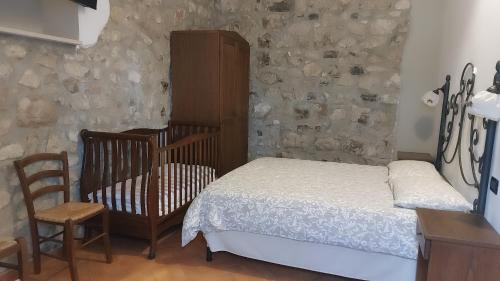 een slaapkamer met een bed, een wieg en een stoel bij Tenuta Chianchito in San Giovanni Rotondo