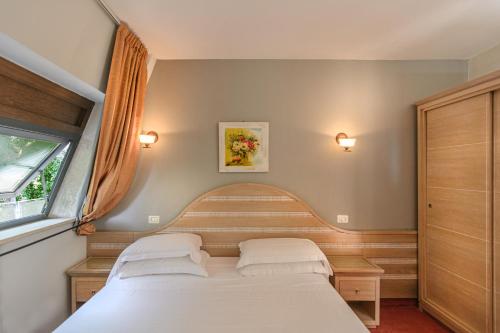 a bedroom with two beds and a window at Hotel Nedy in Marina di Massa