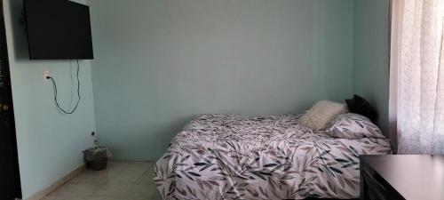 a bedroom with a bed with a purple comforter at Habitación en casa particular in Monterrey