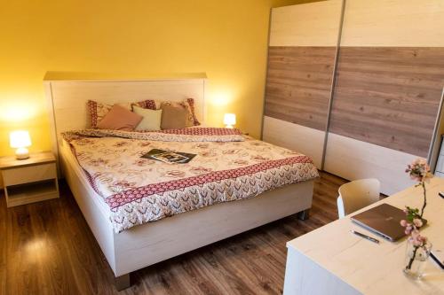 a bedroom with a bed and a desk with a laptop at Detvan – getaway in Poľana mountains in Dúbravy