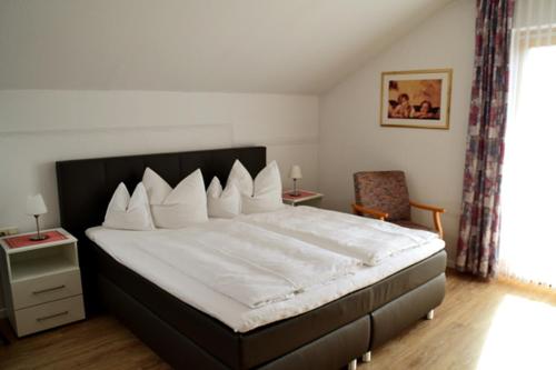 1 dormitorio con 1 cama grande y 1 silla en Pension Anna, en Bodenmais