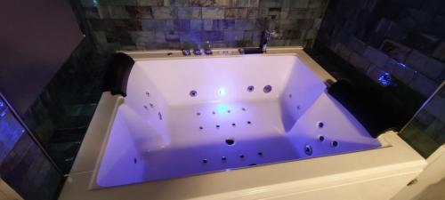 y baño con bañera con iluminación púrpura. en Latorre jacuzzi jerez, en Jerez de la Frontera