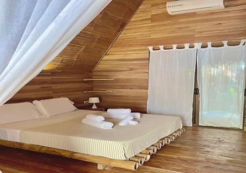 een slaapkamer met een bed met handdoeken erop bij Buena Onda Bungalows in Santa Teresa Beach
