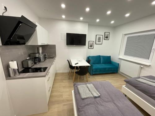 a small kitchen and living room with a blue couch at Deluxe Apartments Messe Flughafen in Leinfelden-Echterdingen