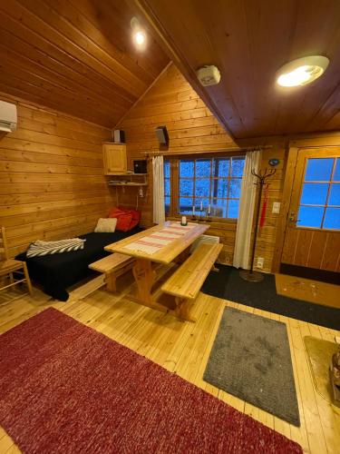 a living room with a wooden table and a couch at Siljonranta in Muonio