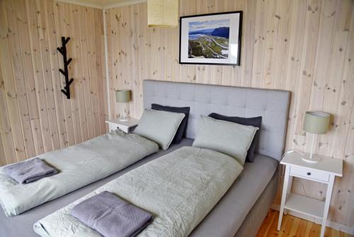 a bed with two pillows on it in a room at Lakeside cottage in Lapland with great view in Skaulo