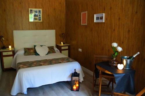 a bedroom with a bed and a table with a candle at Hostal de Montaña Pous de la neu in Alfara de Carles