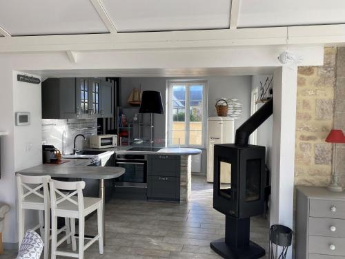 - une cuisine avec une cuisinière au milieu dans l'établissement Les Coquillages de Langrune-sur-mer, à Langrune-sur-Mer