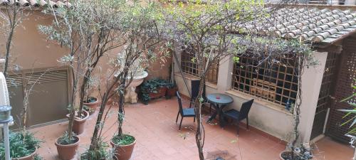 einen Innenhof mit einem Tisch, Stühlen und Bäumen in der Unterkunft Hotel Montreal Uno in Rom