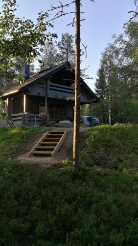 a building with stairs in front of a tree at Siljonranta in Muonio