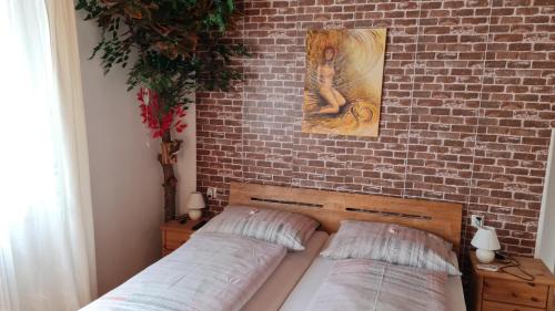 1 dormitorio con 2 camas contra una pared de ladrillo en Urlaubsnest, en Harbach