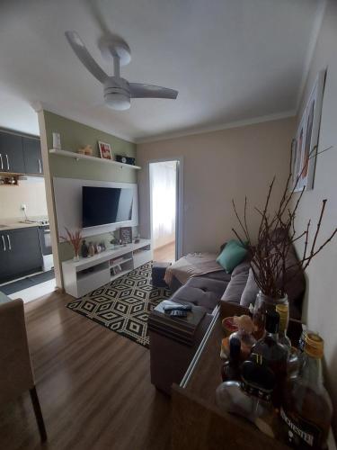 a living room with a couch and a tv at Apto Confortável próximo ao Consulado Americano in Porto Alegre