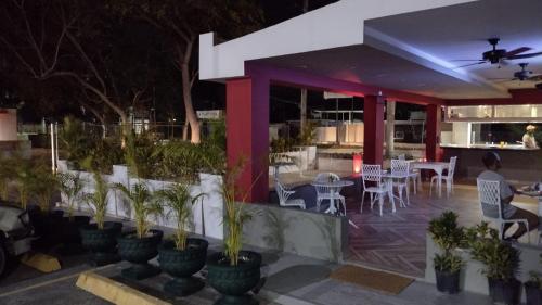 a restaurant with potted plants in front of it at night at Plaza Coral Hotel in Punta Cana