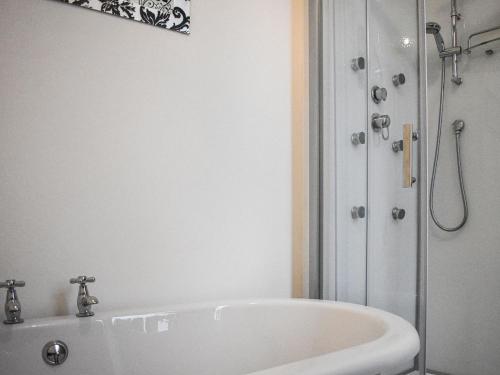 a white bath tub in a bathroom with a shower at Stanton House - Abbey View in Whitby