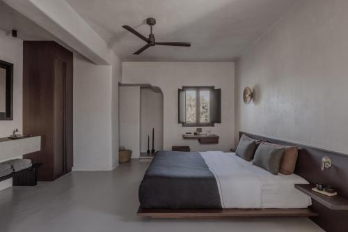 1 dormitorio con 1 cama grande y ventilador de techo en Casa Cook Mykonos - Adults Only en Ornos