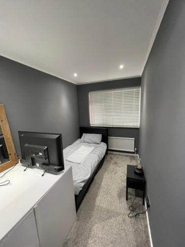 ティルベリーにあるTilbury Docks Rooms for Short lettingの小さなベッドルーム(ベッド1台、テレビ付)