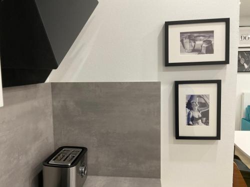 a wall with two framed pictures and a trash can at Deluxe Apartments Messe Flughafen in Leinfelden-Echterdingen