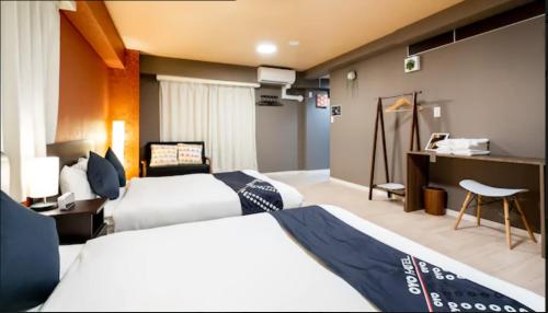 ein Hotelzimmer mit 2 Betten und einem Schreibtisch in der Unterkunft akihabara marutomo hotel in Tokio