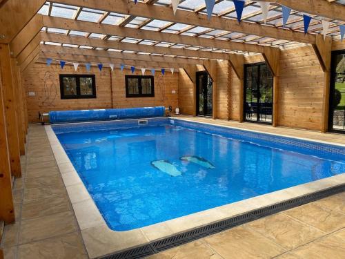 a large swimming pool in a building at 'Monktonmead Lodge' in secluded setting, with private indoor pool. in Ryde