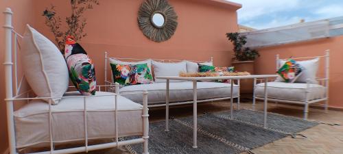 eine Terrasse mit 2 Betten, Kissen und einem Spiegel in der Unterkunft Riad Beni Sidel in Marrakesch