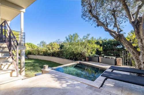 une piscine avec un banc et un arbre dans l'établissement Mougins Collection - Magnifique Maison du Vieux Village de Mougins, avec Bassin à débordement et vues Mer et Montagnes, à Mougins