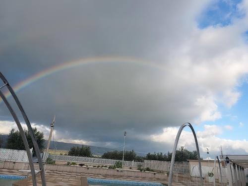 a rainbow in the sky over a swimming pool at Tenuta Chianchito in San Giovanni Rotondo