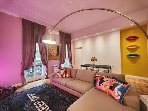 a living room with a couch and a large mirror at Designed Pop Apartment 2 Bedrooms, 2 Baths in Milan Center - WiFi, AC, steps from Subway M1 and M2, Central Station and Airport connected in Milan