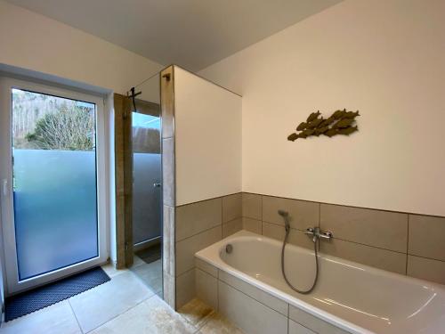 uma casa de banho com banheira e chuveiro em Ferienhaus 'Freund am See' 3 em Heimbach