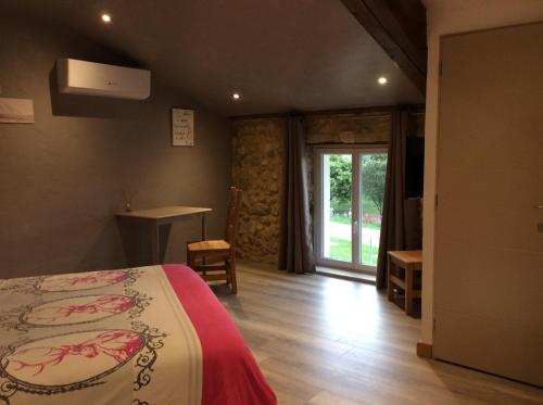 Habitación de hotel con cama y ventana en Le Mas des Figuiers, en Donzère