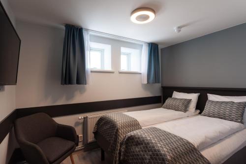 a bedroom with a bed and a chair and a window at The View in Honningsvåg