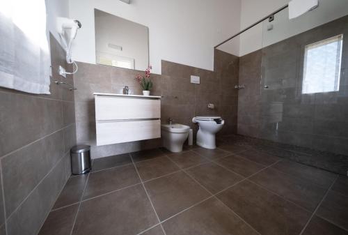 a bathroom with a toilet and a sink and a mirror at Villa Athena Charme in Manerba del Garda