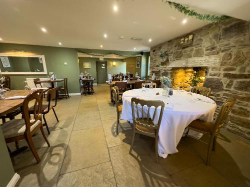 a restaurant with tables and chairs and a stone wall at Thomas Wright House in Byers Green