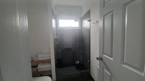 a bathroom with a shower with a glass door at CABAÑAS PAMPAS AUSTRALES in Puerto Natales