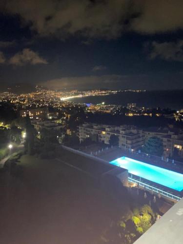 - une vue sur la ville la nuit avec une piscine dans l'établissement NICE BAIE DES ANGES, à Nice