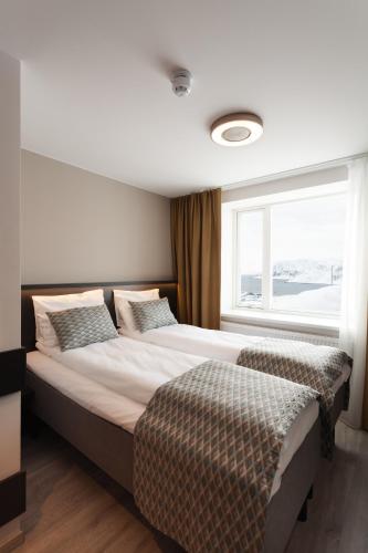 a bedroom with a large bed and a window at The View in Honningsvåg