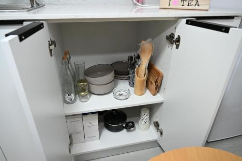 a white kitchen cabinet with food items on it at פסגת הדרור in Shelomi
