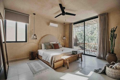 a bedroom with a bed and a large window at Casa Pacha Alma Tulum - Jungle Villa in Tulum