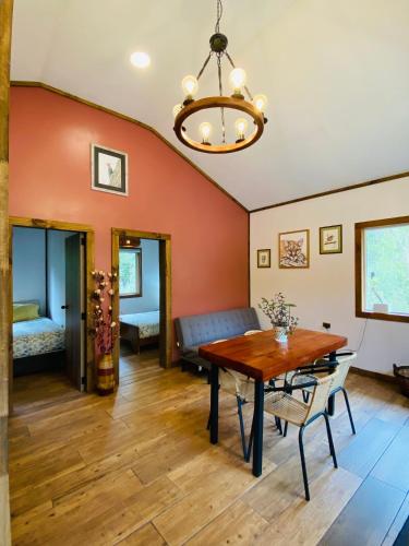 a dining room with a table and a couch at Carpinterito cabaña, ensenada campestre in Puerto Varas