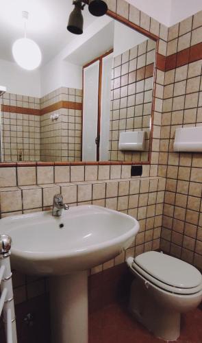 a bathroom with a sink and a toilet and a mirror at 106 gradini in Bottanuco