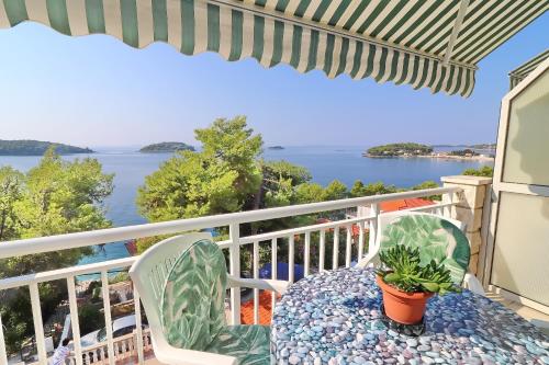 a table and chairs on a balcony with a view of the water at Seaside Apartments Markota in Blato