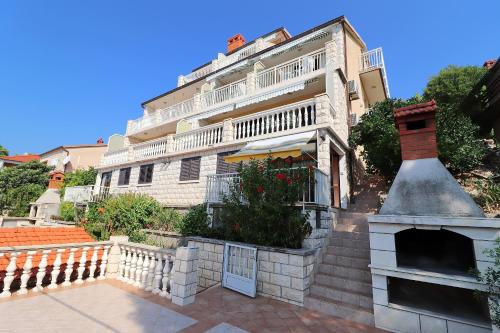 a large white building with a fireplace in front of it at Seaside Apartments Markota in Blato