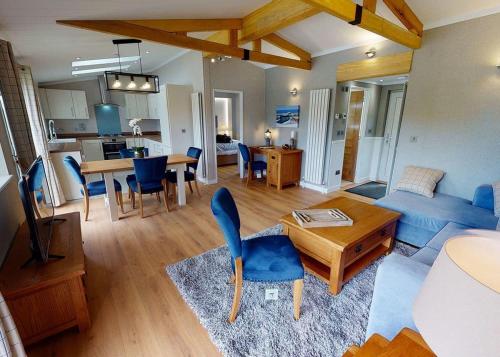 a living room with a blue couch and a table at Willow Lakes Lodges in Ashby cum Fenby