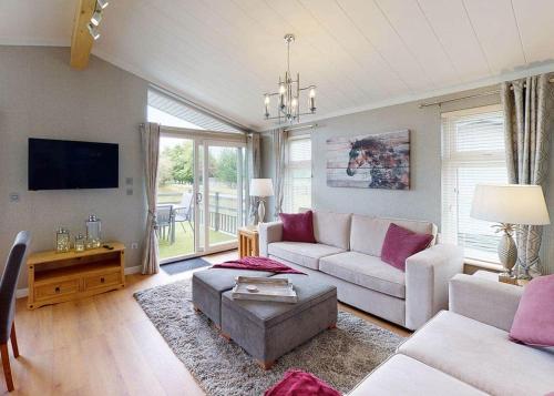 a living room with a couch and a tv at Willow Lakes Lodges in Ashby cum Fenby