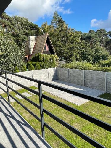 a fence with a bench in front of a house at Balans nad Jeziorem in Ślesin