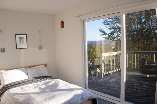 una camera da letto con un letto e una porta scorrevole in vetro di Lakeview Home by Lightrail Downtown & Airport a Seattle